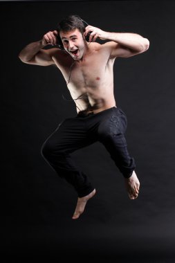 atlama ve dinleme izole müzik gri arka plan genç adam