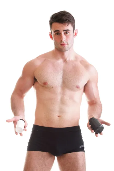 Sexy male body builder holding a boxes with supplements on his b — Stock Photo, Image