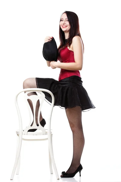 Showgirl woman dance in red corset chair white isolated — Stock Photo, Image