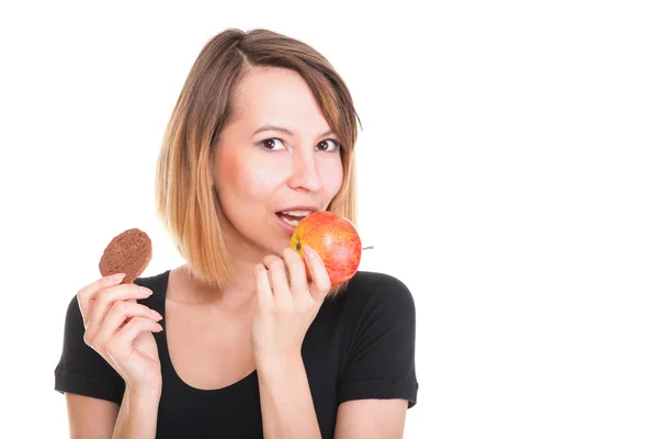 Young beautiful female choose from sweet cake and red apple — Stock Photo, Image
