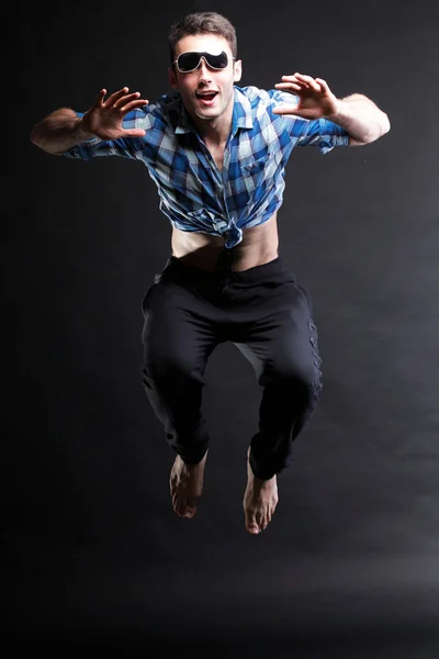Junger Mann springt isoliert grauen Hintergrund — Stockfoto