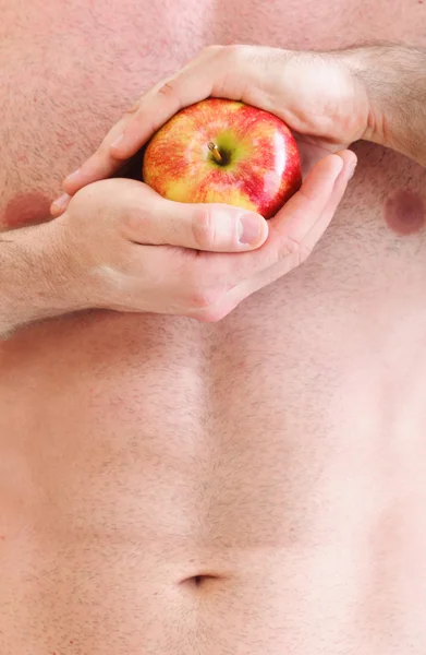 Muscle naked young man torso red apple in hands — Stock Photo, Image