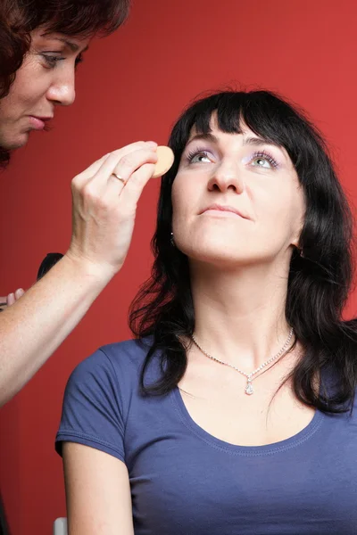 Frau bemalt Gesicht mit Make-up — Stockfoto