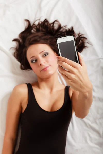 전화 침실에서 침대에 누워 섹시 한 게으른 여자 — 스톡 사진