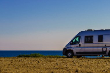 İspanya 'da Akdeniz kıyısında bir karavan. Kumsalda vahşi bir kamp. Tatiller ve karavanla seyahat.