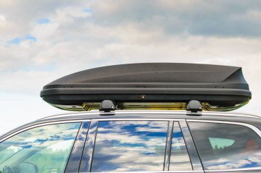 Arabanın çatısında bagaj ya da kargo kutusu var. Seyahat, aile tatili. Ulaşım için aksesuarlar.