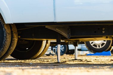 Kamp için otomatik seviye sistemi. Hidrolik sabit bacak kullanımda. Arkadaki karavan için mavi rampa tıkanıklığı.