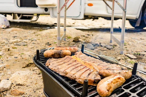 烤肉烤架上的肉和香肠 户外烧烤晚餐 夏季食物 后背的Rv野营车 — 图库照片