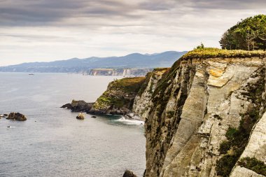 Kuzey İspanya 'daki Asturias kıyısındaki Rocky uçurumları manzarası. Faro de Cabo Busto 'dan görüntü. Turistik yerler, ziyaret edilecek yerler..