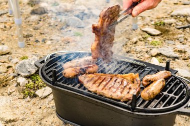Et ve sosis ızgarada. Barbekü yemeği, yaz yemeği..