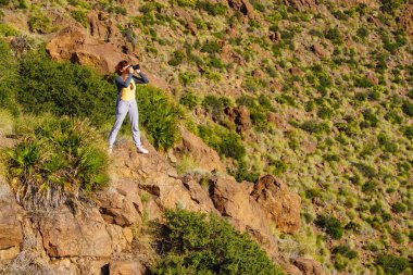 Kamerayla gezen turist kadın, İspanya 'nın Akdeniz doğasında gezerken fotoğraf çekiyor..