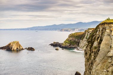 Kuzey İspanya 'daki Asturias kıyısındaki Rocky uçurumları manzarası. Faro de Cabo Busto 'dan görüntü. Turistik yerler, ziyaret edilecek yerler..