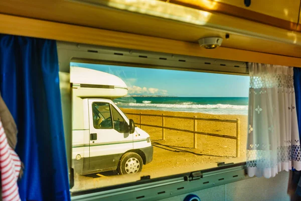 透过大篷车的窗户可以看到在海滩上露营的野营者 驾驶汽车回家冒险 — 图库照片