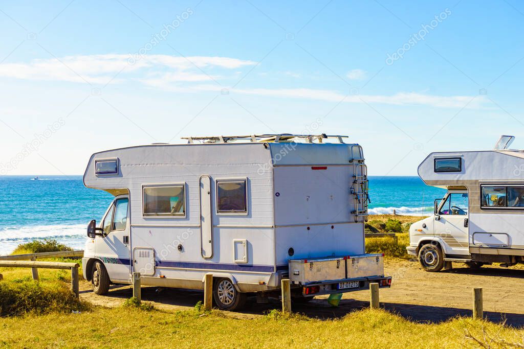 Camper cars rv camping on beach sea shore, sunny summer day. Spain Murcia region, Calblanque Regional Park.