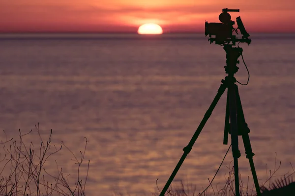 Tripod Üzerindeki Profesyonel Kamera Deniz Üzerinde Güneşin Doğuşunu Gösteren Bir — Stok fotoğraf