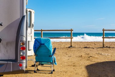 Akdeniz kıyısında sandalyeli karavan, İspanya. Kumsalda vahşi bir kamp. Tatiller ve karavanda seyahat.