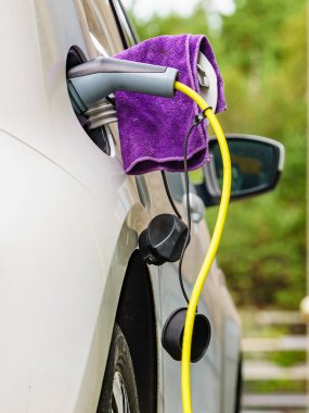 Şarj istasyonunda elektrik prizi olan elektrikli bir araba. Ekolojik ulaşım. Otomotiv teknolojisi kavramı.