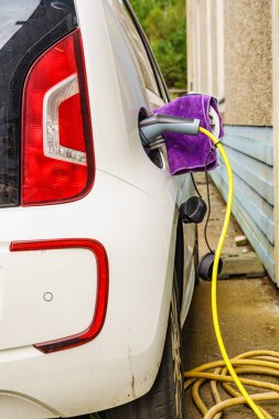 Şarj istasyonunda elektrik prizi olan elektrikli bir araba. Ekolojik ulaşım. Otomotiv teknolojisi kavramı.