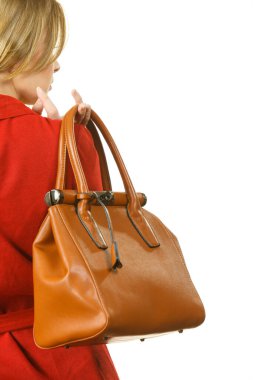 Zarif kırmızı kısa elbiseler giyen ve elinde şık kıyafetler sunan deri bir çanta tutan şık, güzel bir bayan..