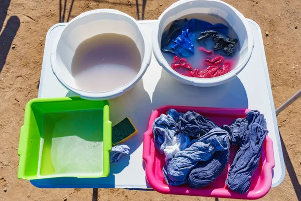 在户外洗前先把衣服浸泡一下 有肥皂水和洗衣粉的碗大自然的露营 — 图库照片