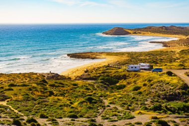 Sahilde kamp yapan karavanlı deniz manzaralı bir karavan. İspanya Murcia bölgesi, Calblanque Bölgesel Parkı.