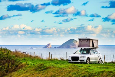 İspanya 'nın Asturias sahilinde çatıda çadırları olan bir araba. Tatiller ve seyahat.