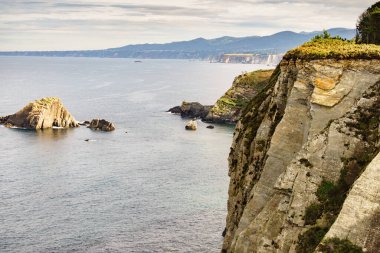 Kuzey İspanya 'daki Asturias kıyısındaki Rocky uçurumları manzarası. Faro de Cabo Busto 'dan görüntü. Turistik yerler, ziyaret edilecek yerler..