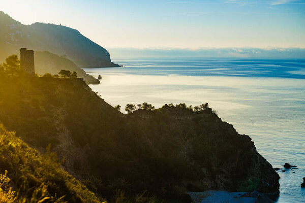 Coastal landscape with old tower. Torre Del Pino, Pine tower on cliffs of Maro Cerro Gordo Natural Park, Malaga province, Costa Del Sol, Andalusia in Spain.
