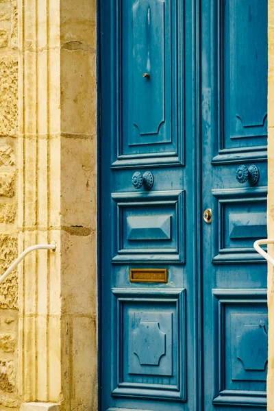 Eski ahşap mavi giriş kapısı olan taş ev cephesi. Fransa 'da mimarlık.