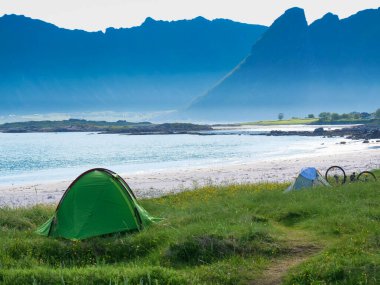 Yazın deniz kıyısında çadır. Okyanus kıyısında kamp yapmak. Lofoten takımadaları Norveç. Tatil ve seyahat.