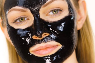 Yüzünde kozmetik olan genç bir kadın, karbonhidrat temizleme maskesi. Spa tedavisi. Cilt bakımı.