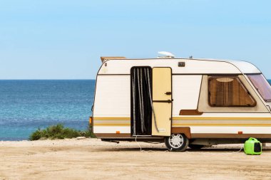Karavan karavanı deniz kıyısında kamp yapıyor. Mobil evle tatil gezisi.