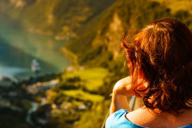 Turist kadın, Flydalsjuvet bakış açısından fiyort Geirangerfjord 'un manzarasının tadını çıkarıyor. Seyahat ve seyahat.