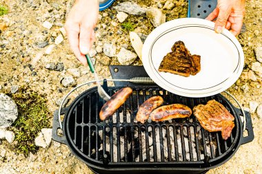 Et ve sosis ızgarada. Barbekü yemeği, yaz yemeği..