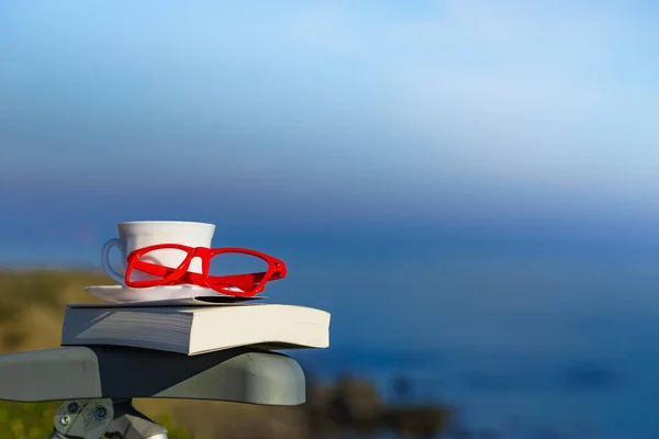 精神的な癒し 精神的な沈黙 コーヒーカップ 赤メガネ海岸に対して 休暇で読書 休日のリラクゼーション 精神衛生上の休憩 — ストック写真