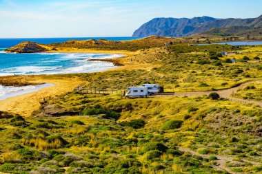 Sahilde kamp yapan karavanlı deniz manzaralı bir karavan. İspanya Murcia bölgesi, Calblanque Bölgesel Parkı.