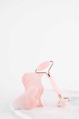 Gua Sha 'nın doğal kuvars taşından yapılmış yüz masajı tekniği. Evde kaldırma ve tonlama tedavisi için yüz masajı..