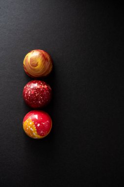 Üst üste yerleştirilmiş farklı renklerde çikolatalı şekerlemelerle modern el resmi. Ürün reklamcılığı konsepti 