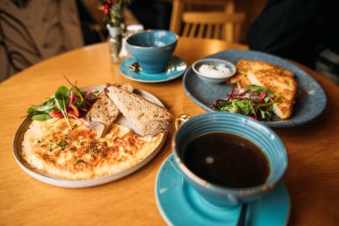 Kafede kahvaltı yumurtaları ve bir fincan kahve.