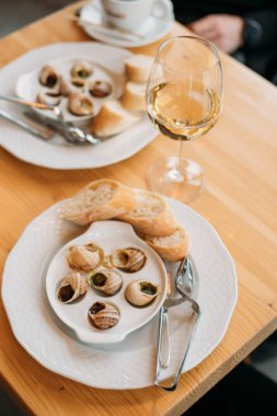 Fransız salyangoz tabağı ve bir bardak şarap.