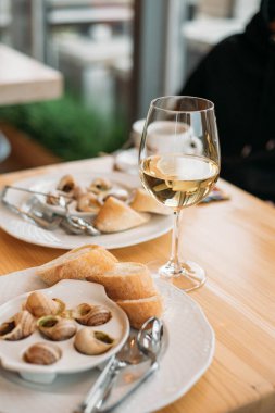 Fransız salyangoz tabağı ve bir bardak şarap.