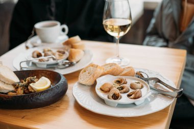 Fransız salyangoz tabağı ve bir bardak şarap.