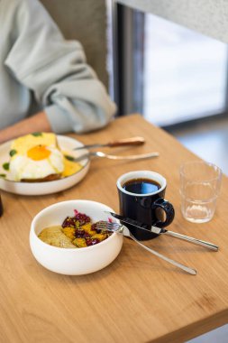 Genç adam kahvaltıda sandviç yiyor.