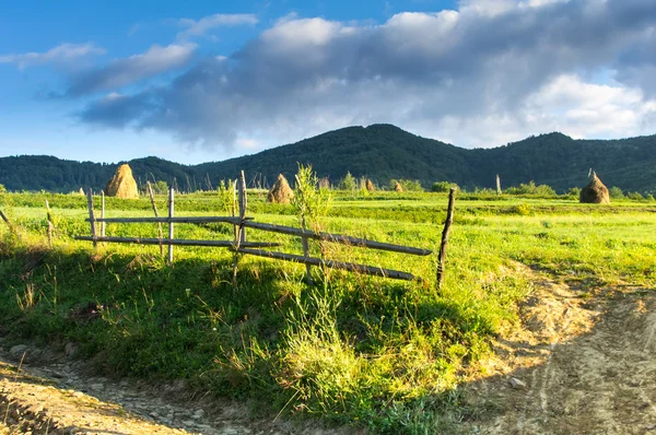 ahşap çit dağlarda bir köyde yapışır.