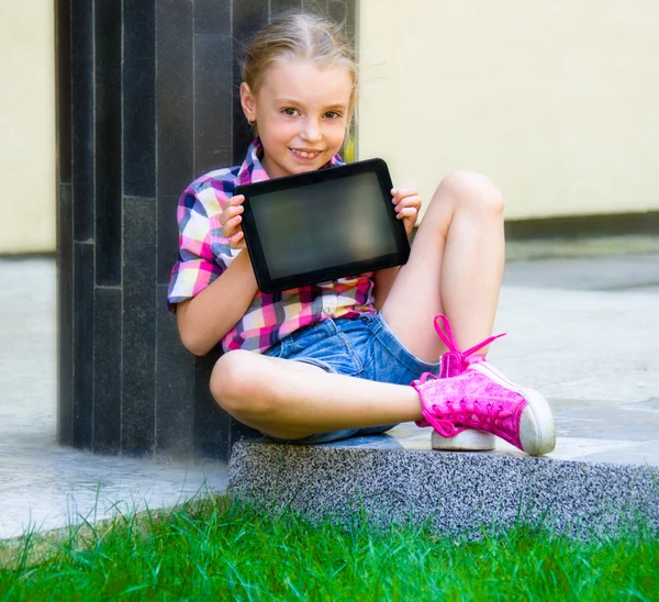 Chica joven sentada con una tableta —  Fotos de Stock