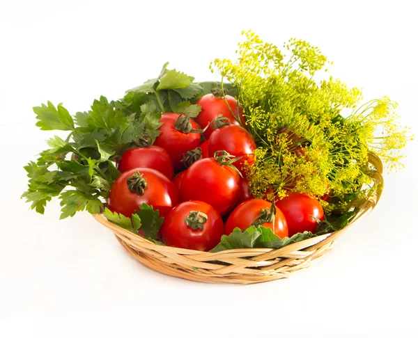 Tomatoes with parsley in wicker plate — Stock Photo, Image