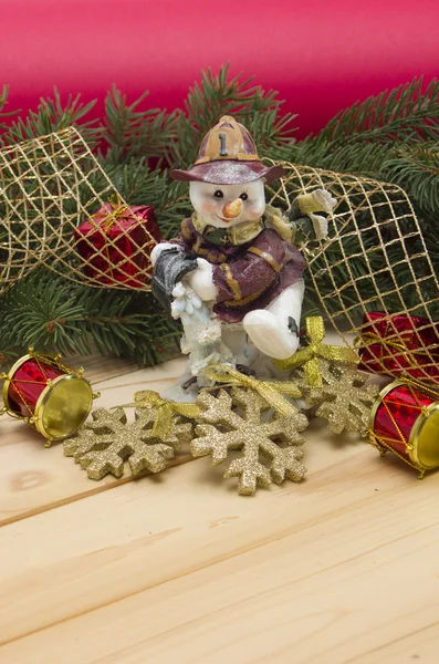 Sneeuwmannen, pijnboomtakken en speelgoed. — Stockfoto