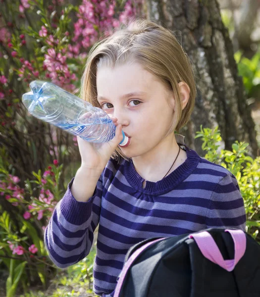 Weinig schoolmeisje water drinkt — Stockfoto