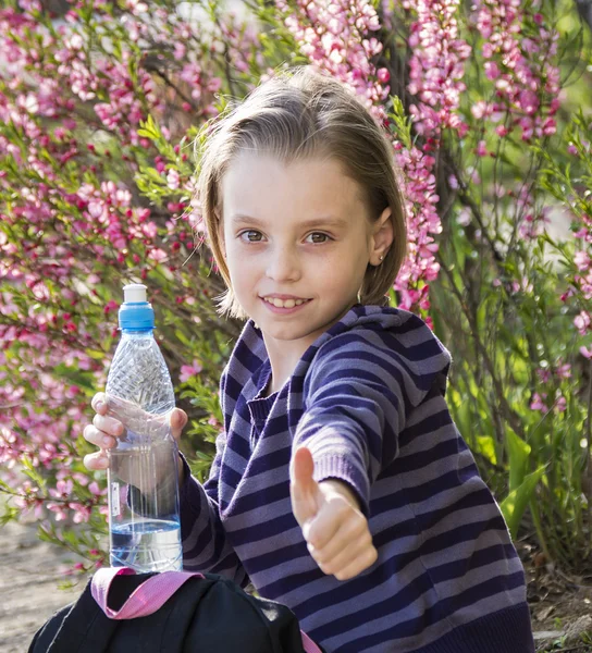 Little schoolgirl  drinks water — Stock Photo, Image