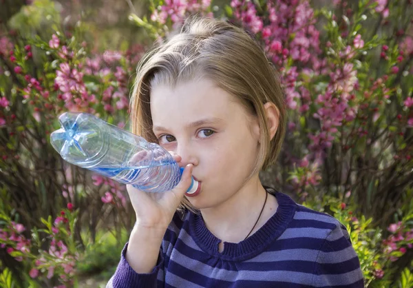 Weinig schoolmeisje water drinkt — Stockfoto